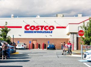 People with shopping carts filled with groceries goods, products walking out of Costco store in Virginia in parking car lot