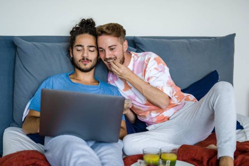 two men watching a movie on laptop