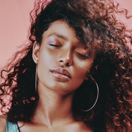 Shot of a beautiful young woman wearing makeup while posing against a pink background