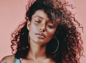 Shot of a beautiful young woman wearing makeup while posing against a pink background