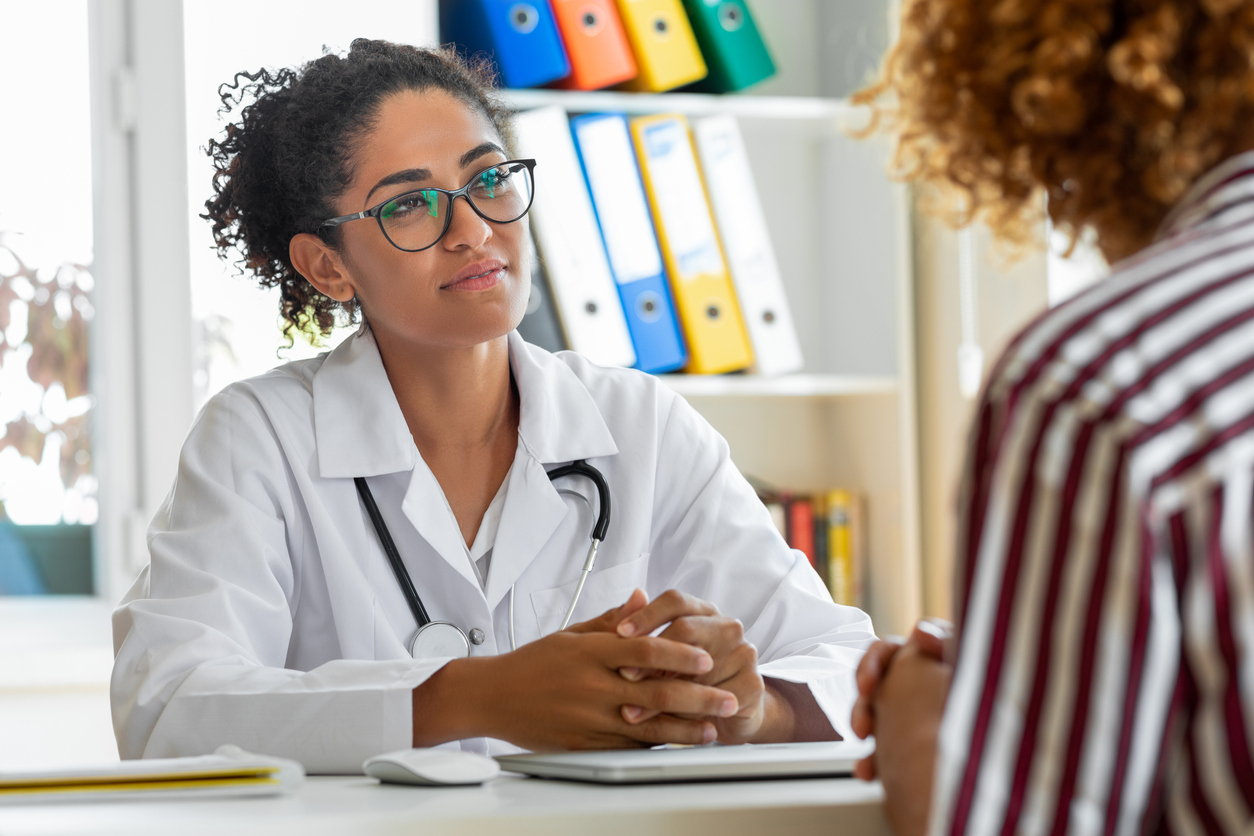 Female patient speaking with her physician in a doctors office