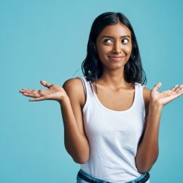 east asian woman smirking and shrugging