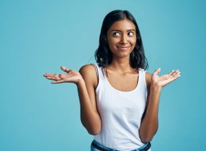 east asian woman smirking and shrugging