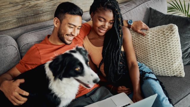 man and woman with dog on couch