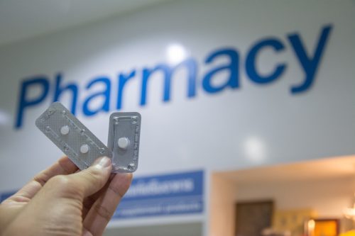 holding emergency contraception in front of pharmacy