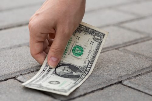 person picking up dollar