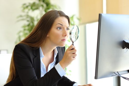Woman Examining the Computer with a Magnifying Glass