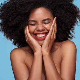 Black Woman Holding Her Face and Smiling