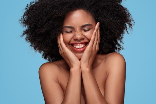 Black Woman Holding Her Face and Smiling