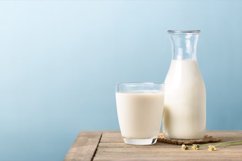Vaso y jarra de leche sobre una mesa