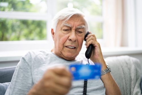 Bărbat în vârstă care dă înșelătorie cu informații despre cardul de credit