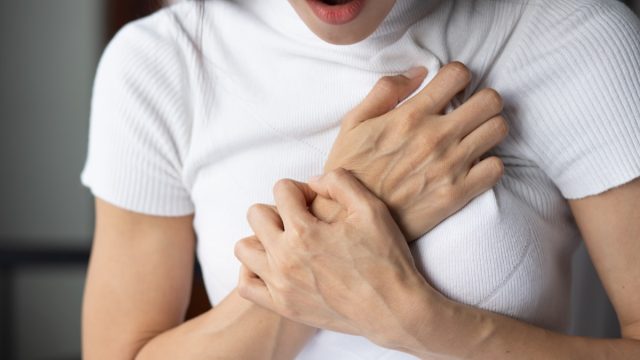 Woman Clutching Her Chest in Pain