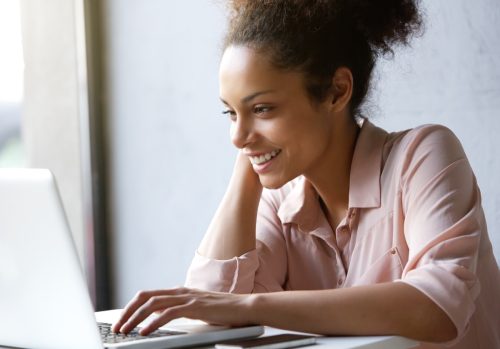 woman smiling while working on computer