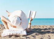 người phụ nữ trên bãi biển đọc sách