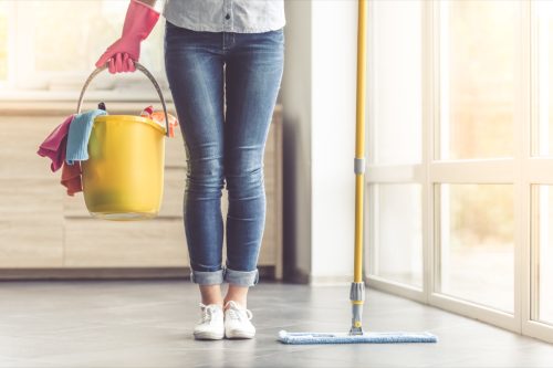 woman with cleaning supplied about to clean house