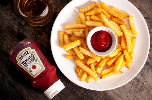 Plate of French fries with a bottle of ketchup