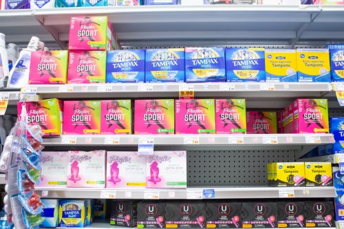  A view of several shelves dedicated to popular brands of tampon products, on display at a local grocery store.