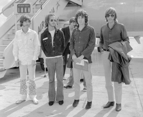 The Doors stand in front of a plane at Heathrow Airport in 1968