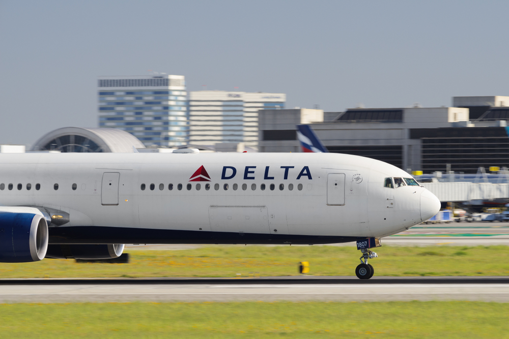 A Delta plane taxiing on the runway at an airport