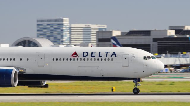 A Delta plane taxiing on the runway at an airport