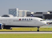 A Delta plane taxiing on the runway at an airport