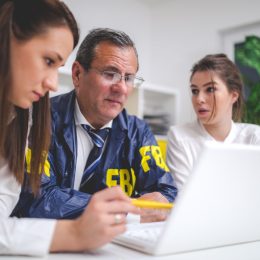Successful FBI people working together in office on computer like a team.