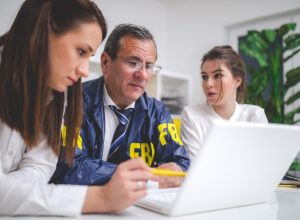 Successful FBI people working together in office on computer like a team.