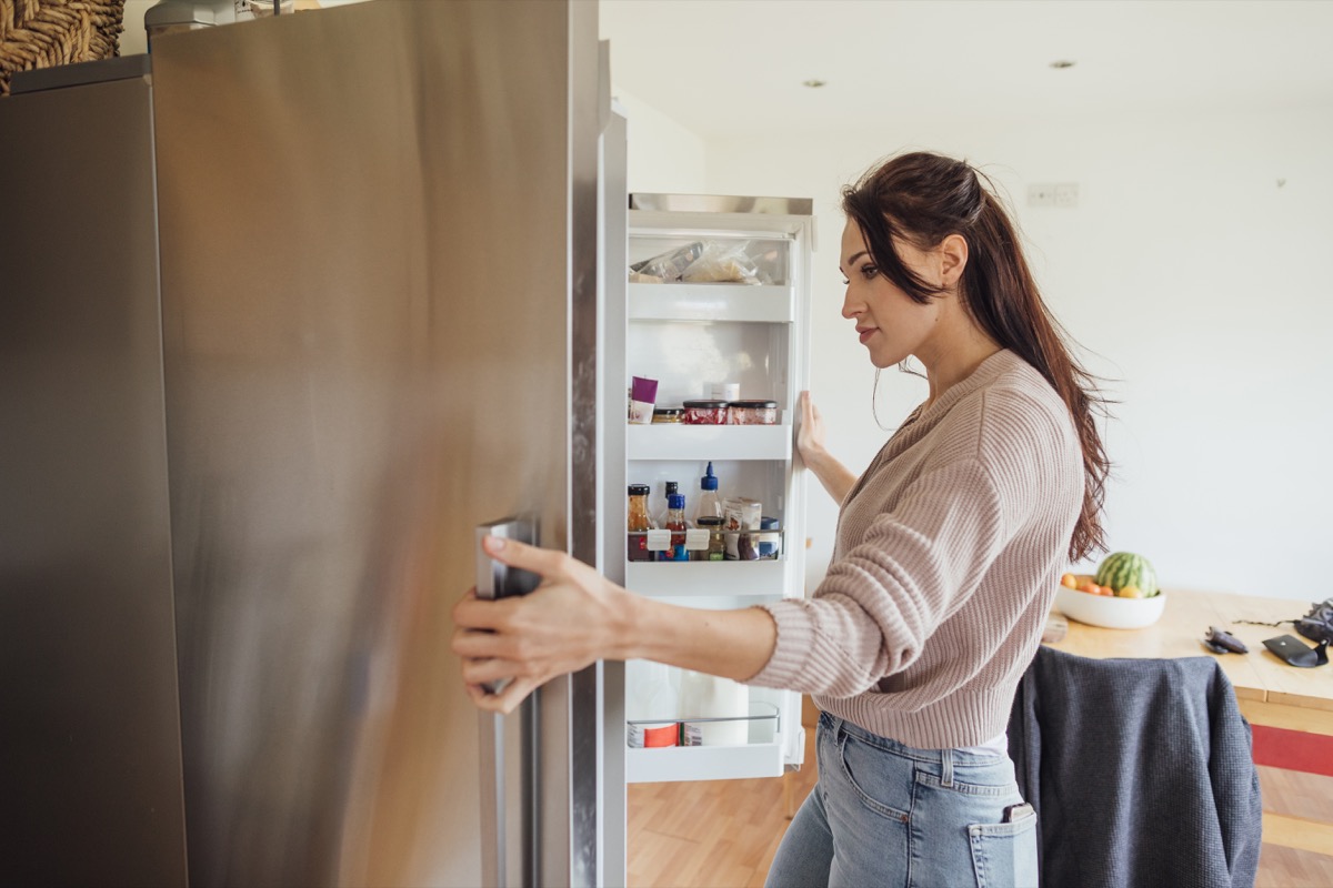 Woman looking into her fridge while taking a study break.