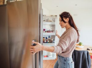 Woman looking into her fridge while taking a study break.