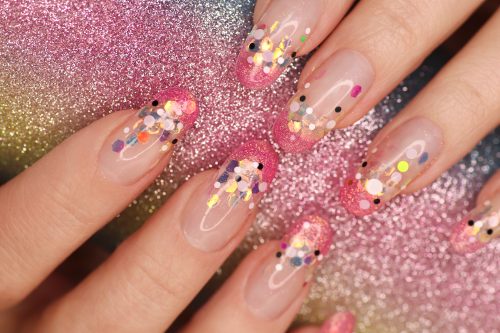 Fashionable aquarium French manicure on long rounded nails with sequins of different sizes.