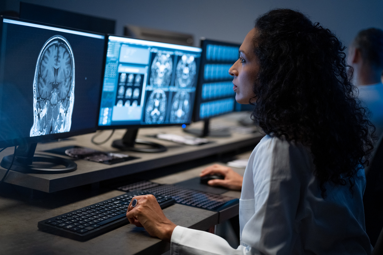 Female radiologist analyzing the MRI image of the head