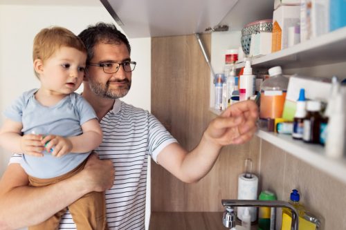 father holding child by medicine cabinet