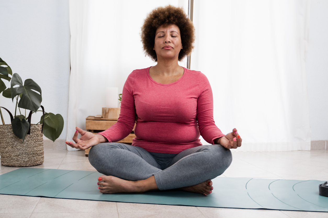 O femeie care face exerciții de respirație și yoga.