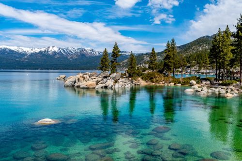 The beautiful crystal clear waters of Lake Tahoe with mountains in the background