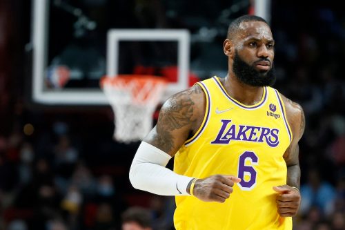 LeBron James jogging in a yellow Lakers jersey at a game against the Trail Blazers on February 9, 2022.