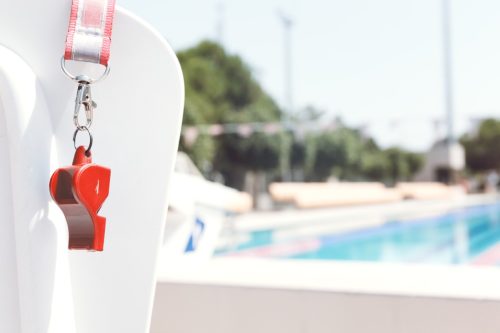 Coach's whistle near the Horizontal outdoor swimming pool.  Living coral theme - color of the year 2019