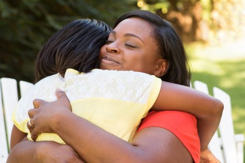 African American mother hugging her daughter.