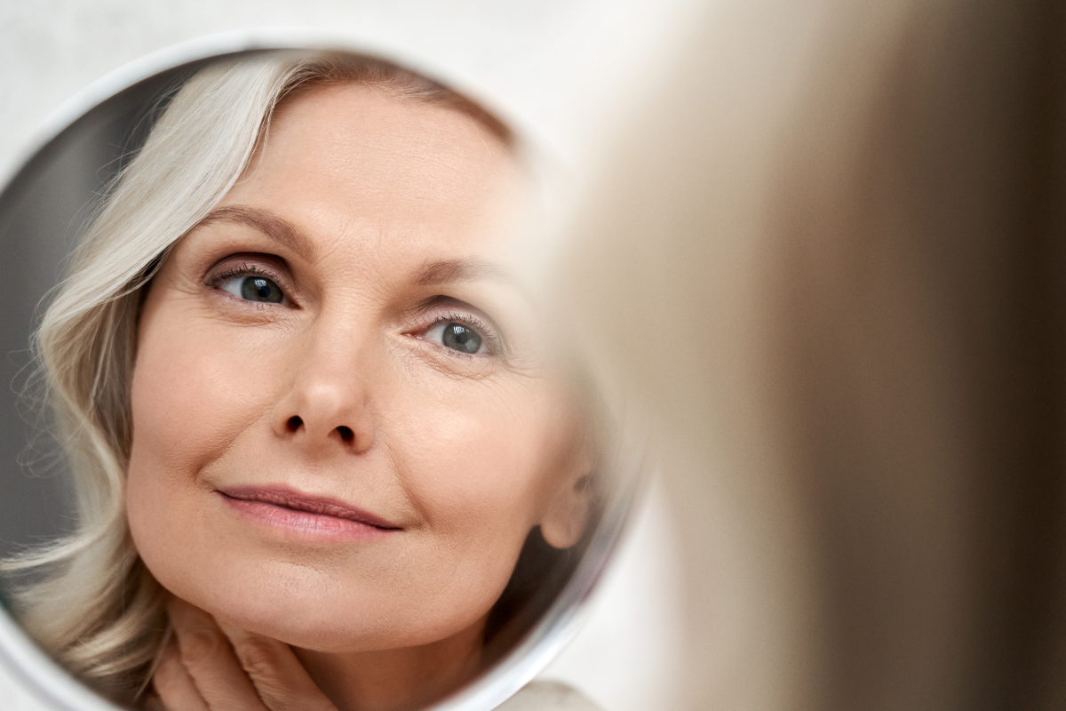 older woman looking in mirror | MercerOnline