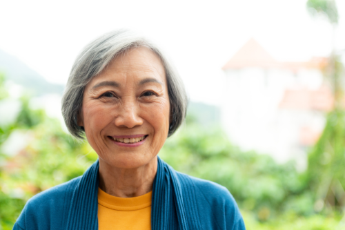 Elderly woman with gray hair smiling outside
