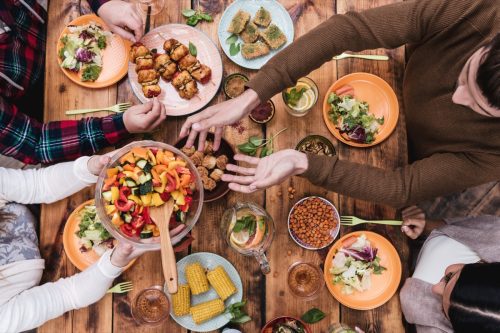 personas cenando juntas con muchos alimentos en la mesa