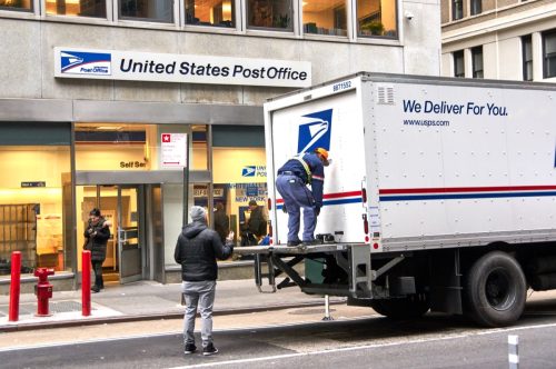 USPS postman on a mail delivery truck in New York. USPS is an independent agenc of US federal government responsible for providing postal service in the US.
