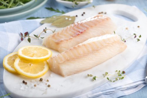 Two Cod Filets on a Plate with Lemon