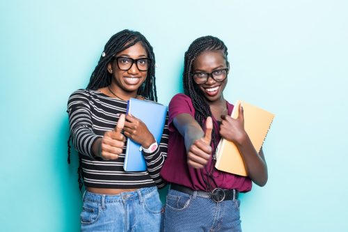 Two Black Girls Holding Notebooks with Thumbs Up