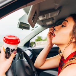 womam doing her makeup while driving