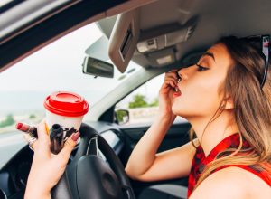 womam doing her makeup while driving