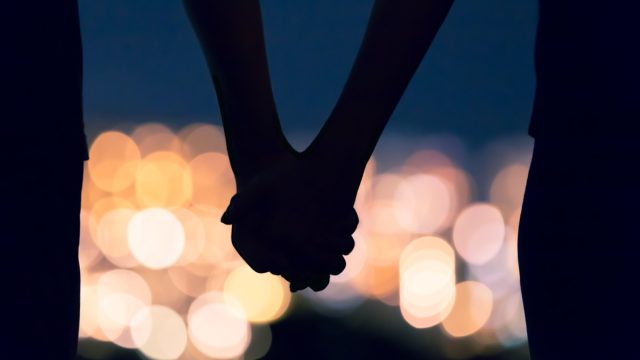 couple holding hands at night