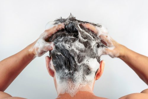 man washes hair
