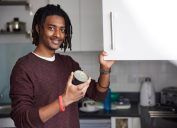 man holding a can of something from the kitchen cupboard