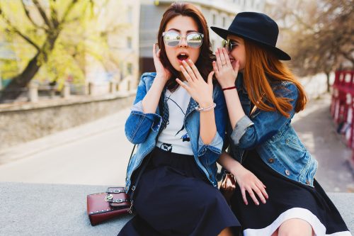 two women gossiping with sunglasses on
