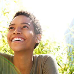 woman smiling in front of trees